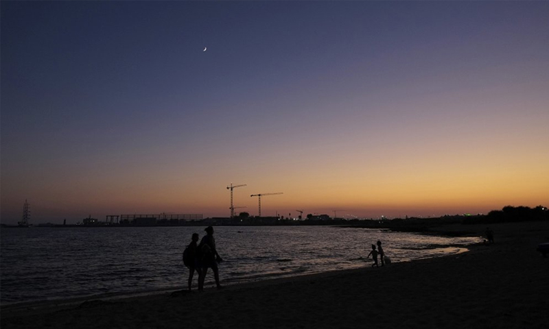 أشخاص يمشون على شاطئ جزيرة قبرص - 22 آب 2020 (AP)