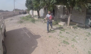 رجل يسعف طفلًا أصيب بقصف النظام على جنوب إدلب - 28 من تشرين الأول 2020 (الدفاع المدني)
