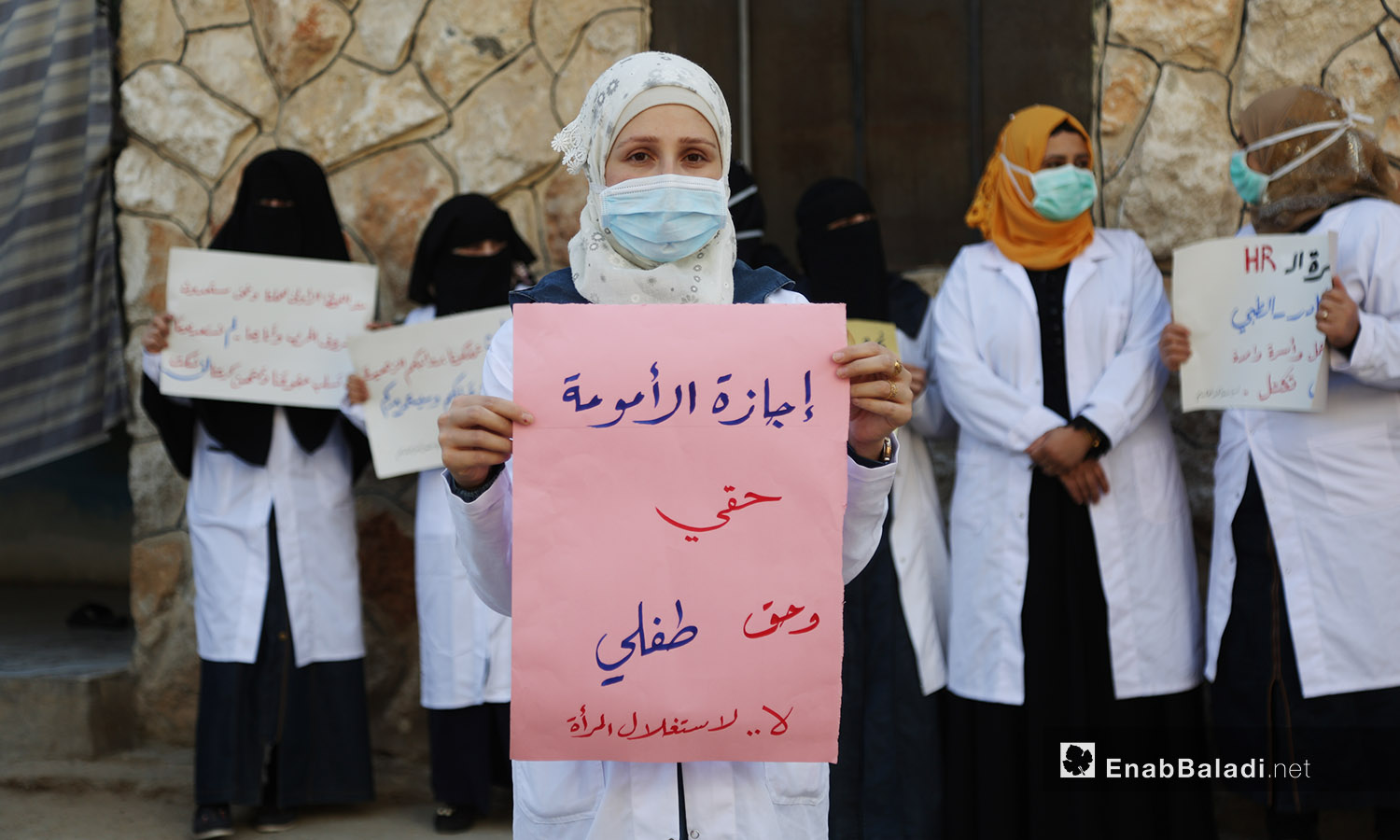 امرأة تحمل لافتة للمطلبة بإجازة الأمومة بوقفة احتجاجية في المشفى النسائي بكفر تخاريم بريف أدلب -11 تشرين الأول 2020 (عنب بلدي /يوسف غريبي)