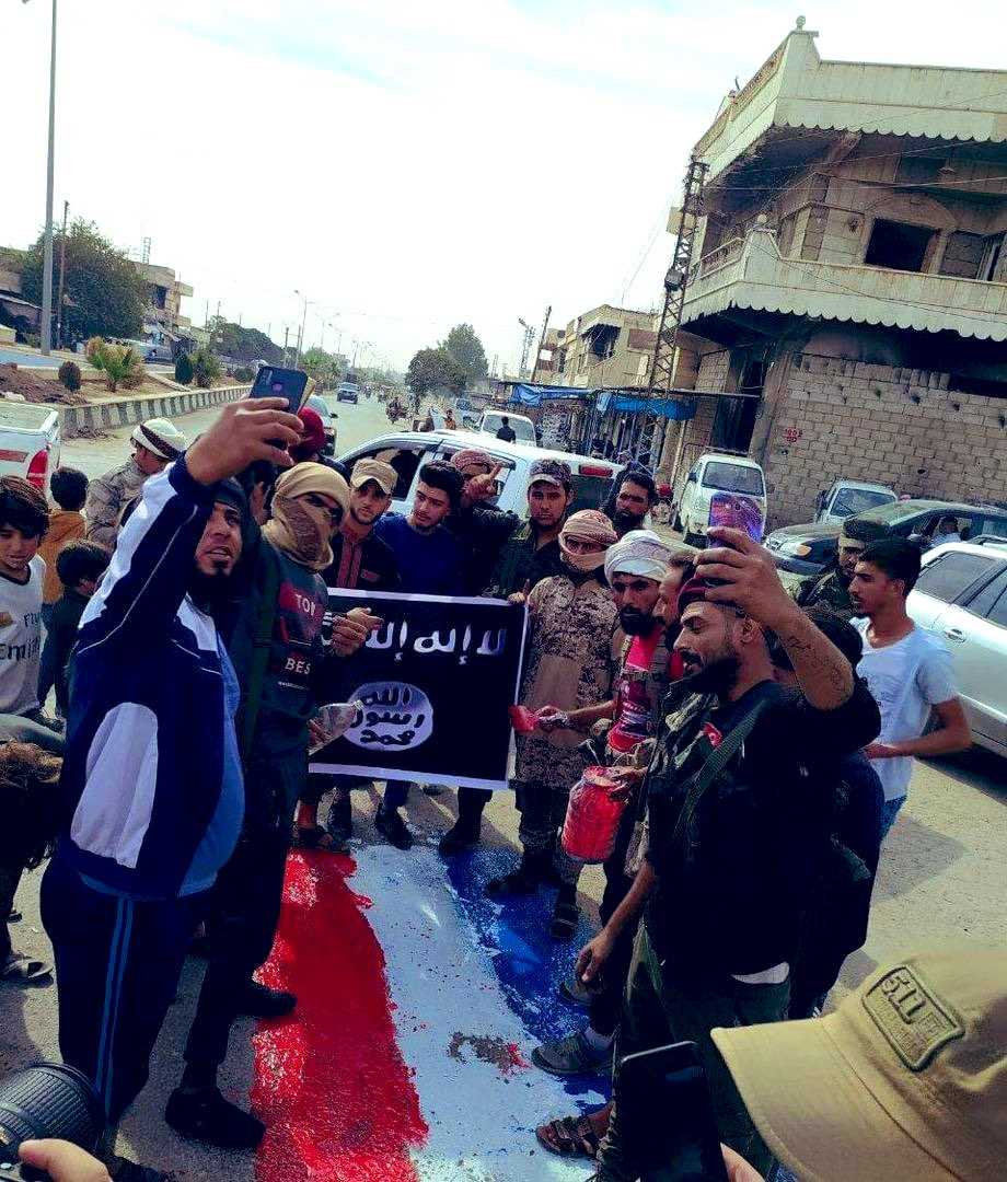 متظاهرون يحملون رايات في منطقة رأس العين بريف الحسكة (ناشطون)