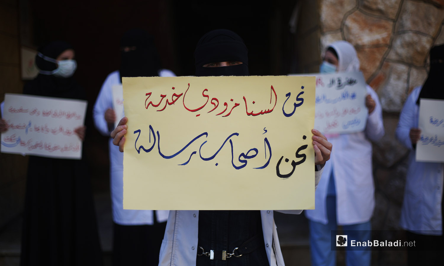 امرأة تحمل لافتة بوقفة احتجاجية بكفرتخاريم بريف أدلب -11 تشرين الأول 2020 (عنب بلدي /يوسف غريبي)