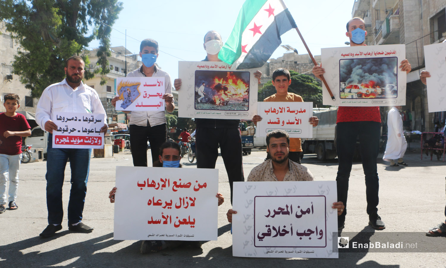 شارك الناشطون في الوقفة الاحتجاجية بمدينة إدلب رافعين لافتات تدين الانتهاكات بحق المدنيين في سوريا - 9 تشرين الأول 2020 (عنب بلدي/ أنس الخولي)