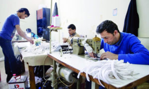 عمال سوريون في ورشة خياطة (Halk TV)
