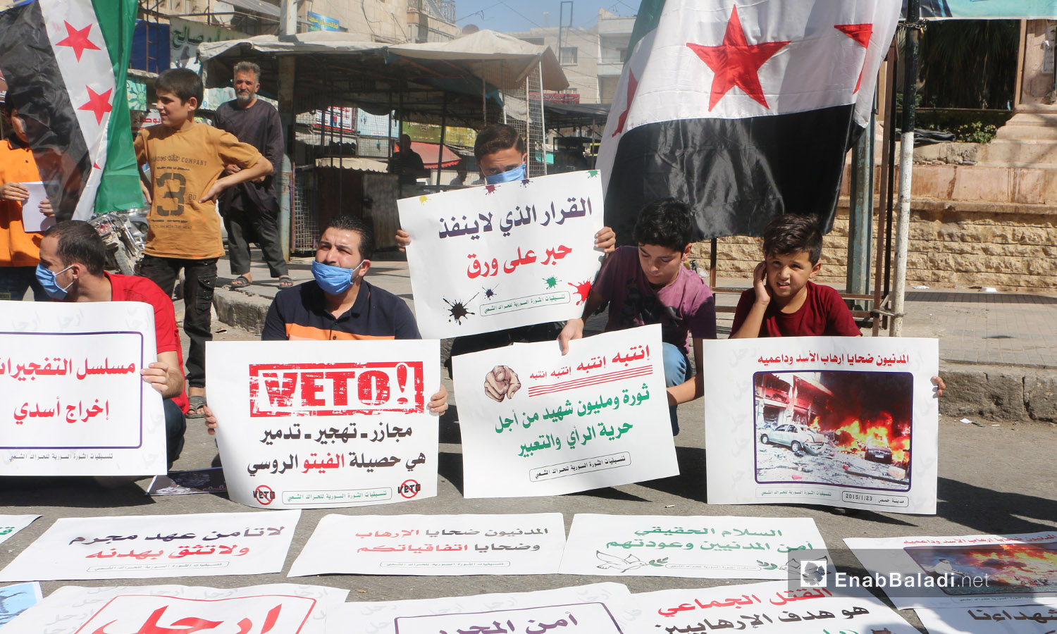 شارك الناشطون في الوقفة الاحتجاجية بمدينة إدلب رافعين لافتات تدين الانتهاكات بحق المدنيين في سوريا - 9 تشرين الأول 2020 (عنب بلدي/ أنس الخولي)