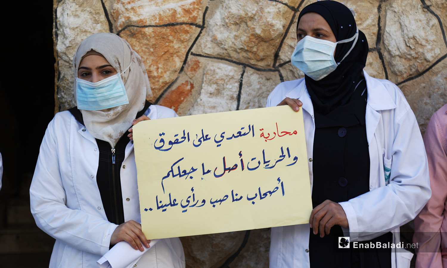 نساء يحملن لافتة بوقفة احتجاجية لدعم الكادر الطبي النسائي في كفر تخاريم -11 تشرين الأول 2020 (عنب بلدي /يوسف غريبي)