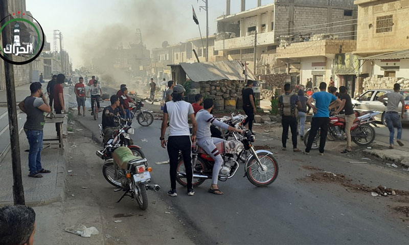 صورة من تجمع مواطنين عند الحاجز الأمني الذي حرق في مدينة درعا 26 من تشرين الأول 2020 (صفحة الحراك في فيس بوك)