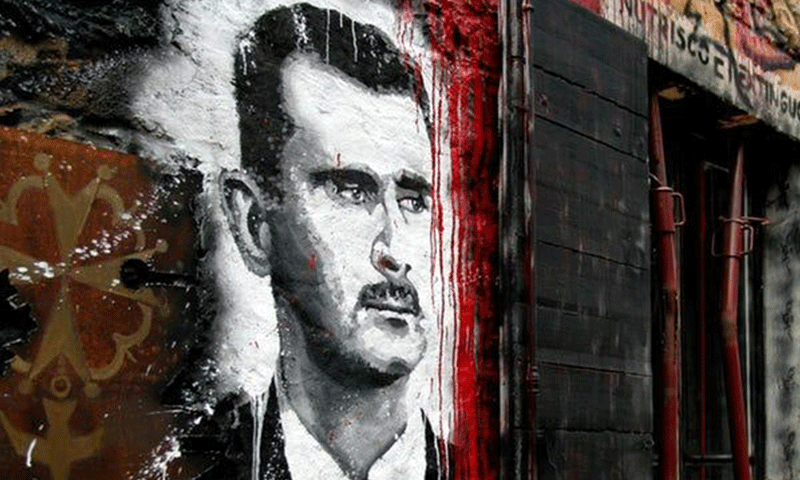 صورة لرئيس النظام السوري على جدار في سوريا- (Thierry Ehrmann)