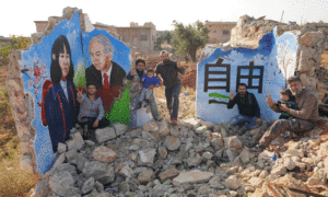 الرسام السوري عزيز الأسمر وصورة صورة الفتاة اليابانية المختطفة ميغومي يوكوتا التي رُسمت على جدار منزل مهدم جراء القصف في مدينة إدلب- 16 من تشرين الثاني 2020 (الرسام والمصور محمد حاج قدور)