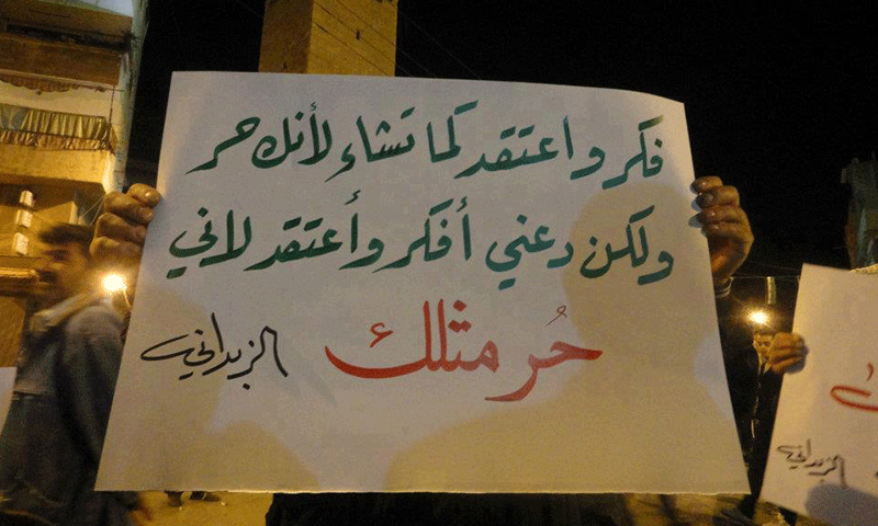 شخص يحمل لافتة في مظاهرة بمنطقة الزبداني في ريف دمشق تدعم حرية التعبير والتسامح بين الآراء المختلفة- تشرين الأول عام 2012 (شبكة الثورة السورية)