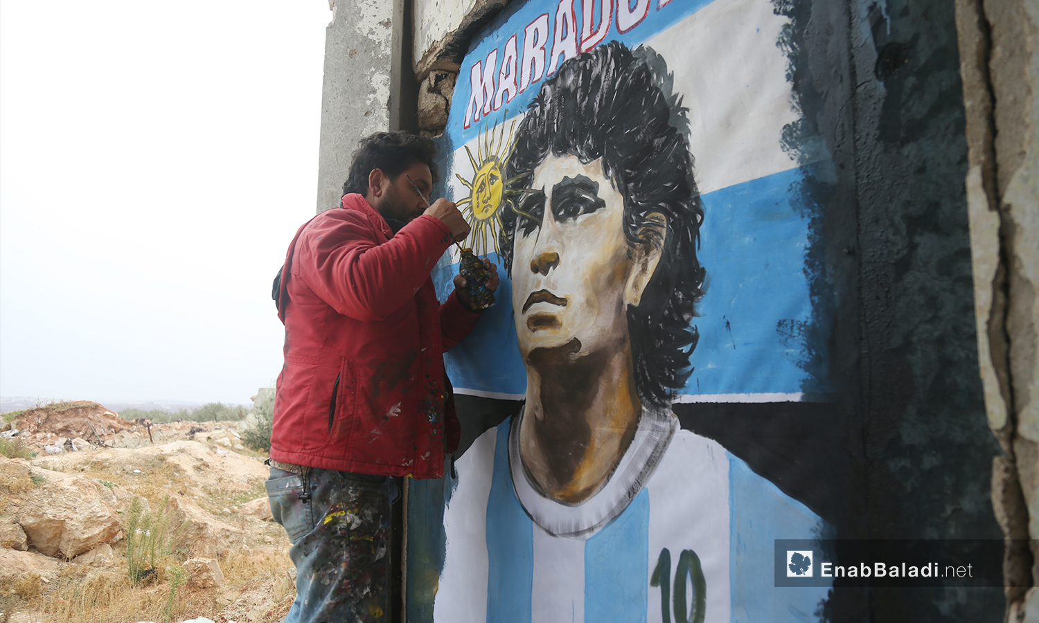 تضمنت الجدارية التي رسمها عزيز الأسمر وجه لاعب كرة القدم دييغو مارادونا مع شعار بلاده - 26 تشرين الثاني 2020 (عنب بلدي/ يوسف غريبي)