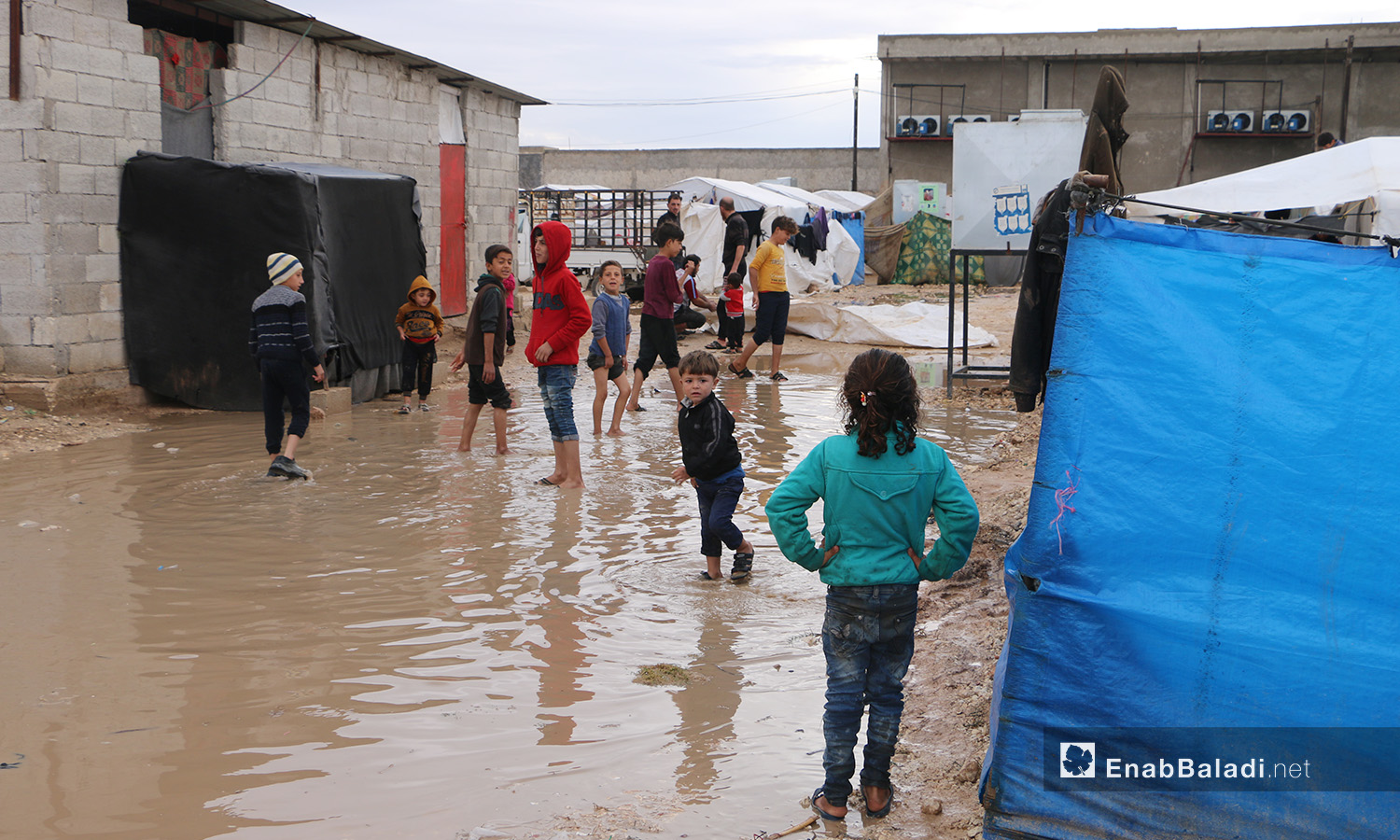 يمشي الأطفال وسط الماء المتجمع داخل وخارج الخيام في مخيم "الفلاح" بريف حلب الشمالي  - 4 تشرين الثاني 2020 (عنب بلدي/ عبد السلام مجعان)