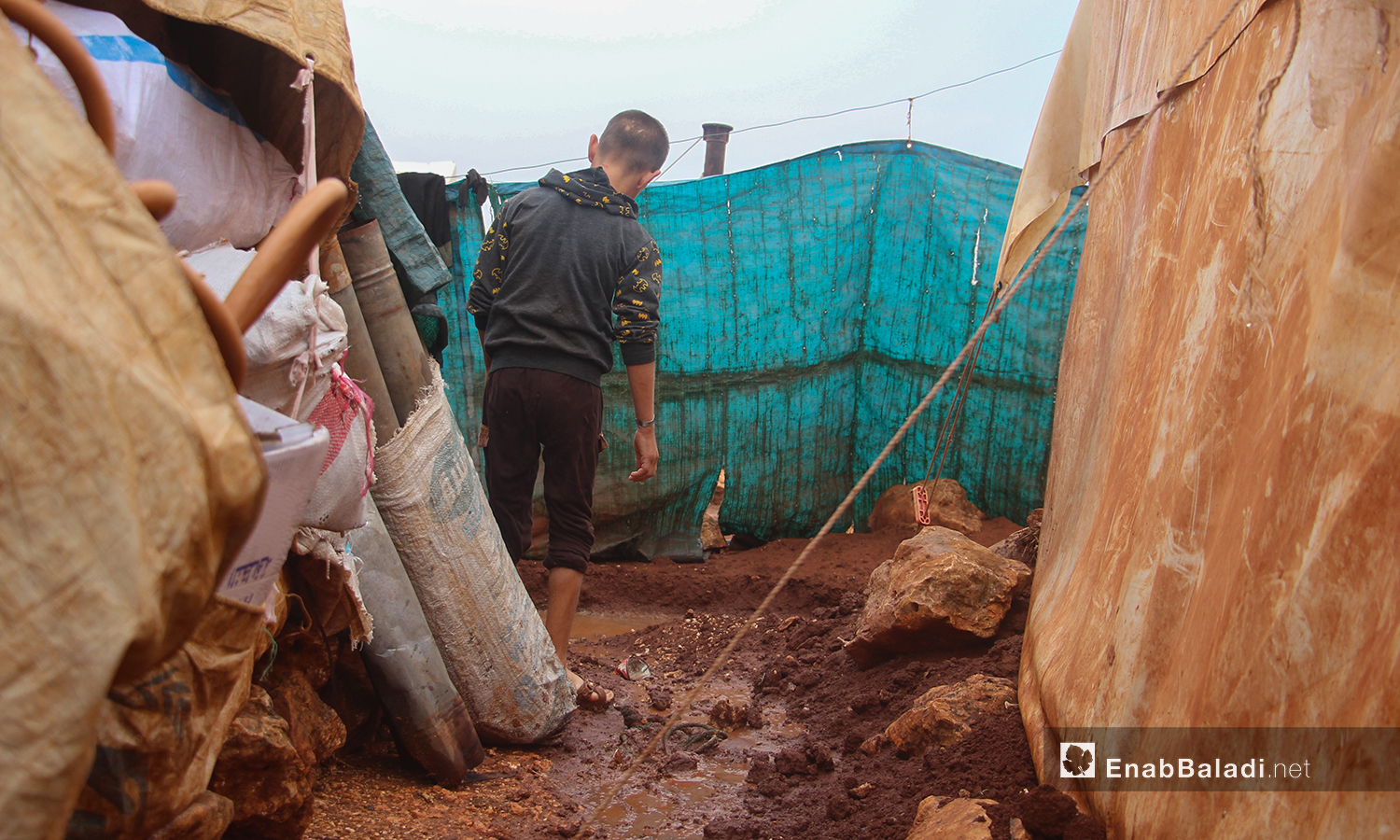 تحولت المساحات الفارغة ما بين الخيام إلى مستنقعات من الطين بعد هطول الأمطار الغزيرة على مخيم الرمضون على أطراف قرية كفر عروق شمالي إدلب - 2 تشرين الثاني 2020 (عنب بلدي/إياد عبد الجواد)
