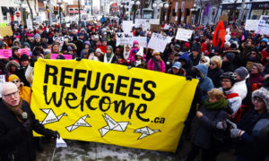 نشطاء من التجمع الشيوعي الكندي يطالبون بوقف محادثات في 2018 بين كندا والولايات المتحدة تحد من استقبال اللاجئين (الحزب الشيوعي الكندي)