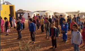 طلاب مدرسة مخيم أبيض قرب مدينة معرة مصرين يتابعون تعليمهم رغم الحاجة للكثير من مقوماته (مديرية التربية في إدلب)