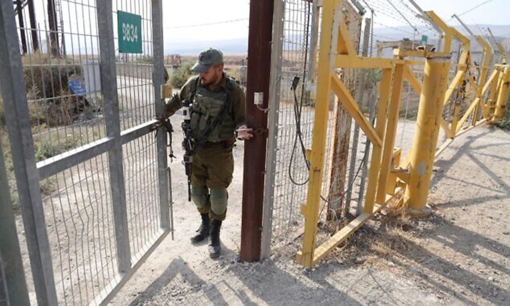 جندي إسرائيلي يغلق بوابة حدودية على الجانب الإسرائيلي من الحدود في موقع نهاريم في غور الأردن. (وكالة الصحافة الفرنسية) 8 من تشرين الثاني 2019