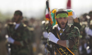 عنصر من الميليشيات الإيرانية في عرض عسكري (رويترز)
