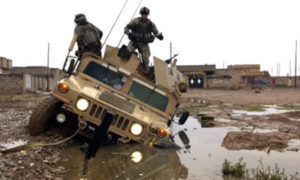 جنود أمريكون ينزلون من سيارتهم بعد أن علقت في الوحل في مدينة كركوك العراقية - 28 من كانون الثاني 2006 (وزارة الدفاع الأمريكية)