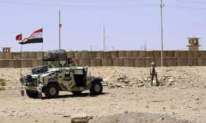 جندي عراقي أمام عربة عسكرية في منطقة القائم على الحدود السورية العراقية (AP)