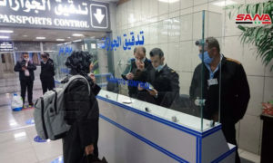 عناصر شرطة وسيدة قي قيم تدقيق الجوازات بمطار حلب الدولي (سانا)