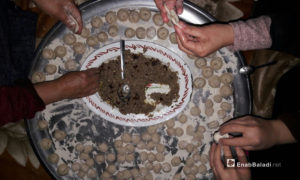 نساء يعددن أكلة الششبرك التي تسمى بآذان الشائب في درعا - 29 كانون الثاني 2021 (عنب بلدي حليم محمد)
