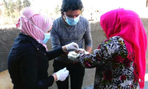 عمال صحيون يعالجون ندبة اللشمانيا على يد امرأة في ريف دير الزور - شباط 2020 (SDF MEDIA CENTER)
