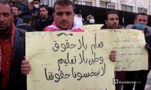 معلم في مدينة إدلب يرفع لافتة ضمن اعتصام بناة الأجيال أمام مديرية التربية بسبب انقطاع الرواتب منذ عامين - 3 شباط 2021 (عنب بلدي - أنس الخولي)