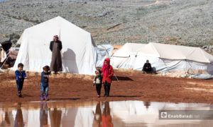 أطفال يقفون أمام خيامهم بعد عاصفة مطرية ضربت مخيم كفرعورق في ريف إدلب - 31 كانون الثاني 2021 (عنب بلدي - إياد أبو الجود)