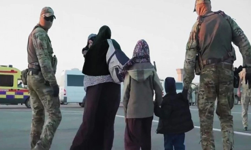 عسكريون كازاخستانيون يرافقون عائلة كازاخستانية أثناء إعادتهم من سوريا خلال عملية "زوسان" (Courtesy Photo)