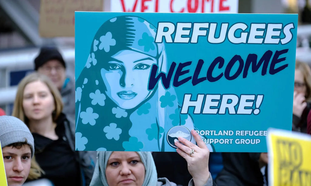 متظاهرون يتظاهرون في مطار بورتلاند الدولي في 27 من كانون الثاني، 2018 ، بعد عام واحد من تطبيق الرئيس دونالد ترامب لقانون حظر دخول الدول ذات الغالبية المسلمة إلى الولايات المتحدة وكالة "AP" الأمريكية