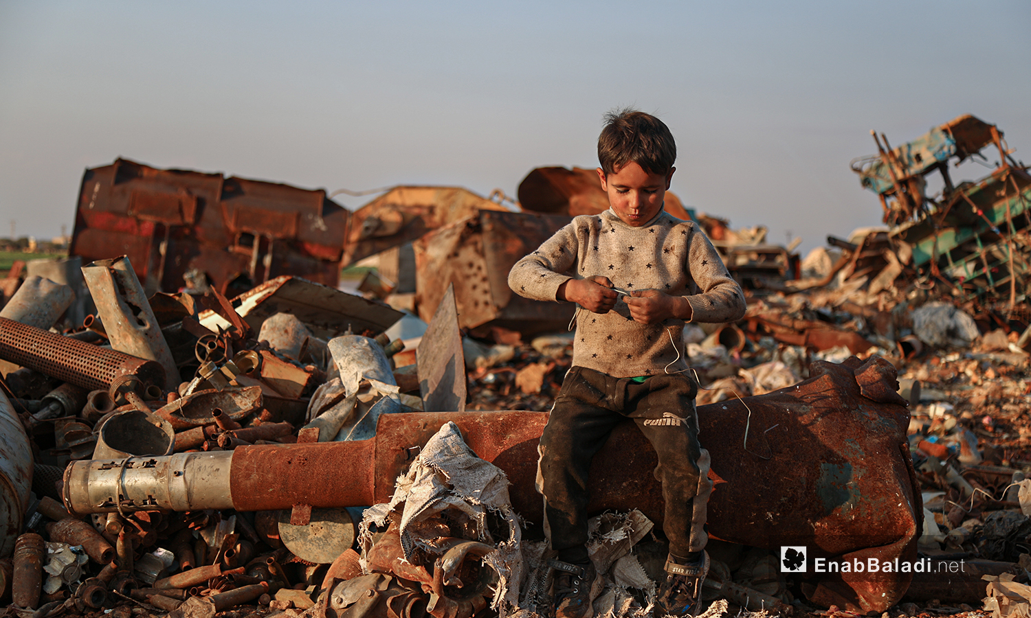 لا يعي الأطفال المخاطر التي يواجهونها في ساحة تفكيك الصواريخ والقذائف غير المتفجرة مع تعرضهم للخطر المستمر في شمال غربي سوريا الذي ما زال يتعرض للاستهداف والقصف منذ نحو عشر سنوات - 5 آذار 2021 (عنب بلدي/ يوسف غريبي)
