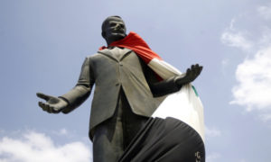 علم النظام السوري ملفوف على تمثال لحافظ الأسد بمدينة حمص - 30 من آب 2011 (AFP)