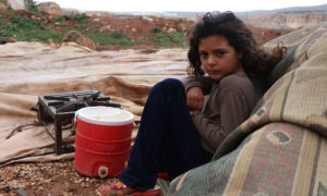 ريناد طفلة سورية بعمر السابعة تجلس على بقايا خيمة عائلتها بعدما اقتلعتها العاصفة_ 25 من آذار (الدفاع المدني السوري)