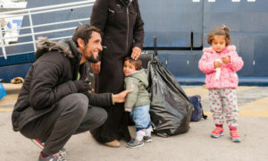 محمد الهاجر وعائلته على رصيف في ميناء بيرايوس، اليونان. تم نقل العائلة من جزيرة ساموس إلى الأراضي اليونانية في إطار برنامج تدعمه المفوضية، 9 آذار 2018 (UNHCR)