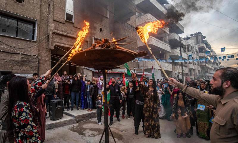 أكراد سوريون يشعلون نار "نوروز" في مدينة القامشلي في محافظة الحسكة شمال شرقي سوريا- 20 من آذار 2021 (DELIL SOULEIMAN/GETTYIMAGES)