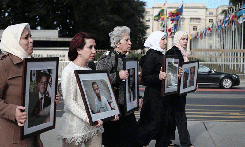 سيدات سوريات أمام مقر الأمم المتحدة في جنيف يحملن صور أقاربهم المعتقلين في سوريا- 2017 (رابطة "عائلات من أجل الحرية")