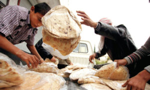 مواطن سوري يحاول التقاط أرغفة الخبز- 2 من آذر (فيس بوك)