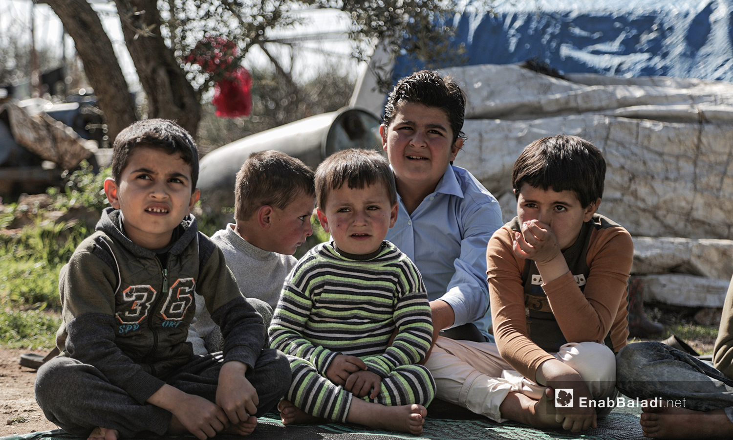 أطفال نازحين يشاهدون عرضا للدمى المتحركة قدمته فرقة الحارة المسرحية في إحدى مخيمات النازحين قرب مدينة إدلب 28 آذار 2021 (عنب بلدي/ تصوير يوسف غريبي).