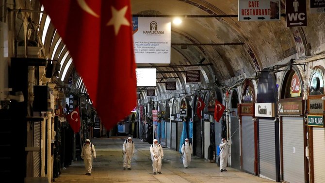 عمال يطهرون سوق البازار الكبير لمنع انتشار فيروس كورونا في إسطنبول (رويترز)