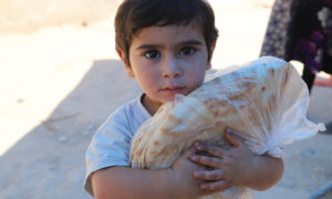 طفل سوري يحتضن ربطة خبز (WFP)