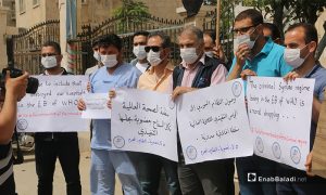 عاملون في مديرية صحة إدلب يحتجون على انتخاب سوريا لعضوية المجلس التنفيذي في منظمة الصحة العالمية- 31 أيار 2021 (عنب بلدي)