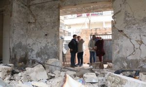 أربعة تلاميذ يقفون في قسم مدرستهم الذي تضرر جراء غارة جوية عام 2018 في إدلب شمال غربي سوريا (Save the Children)