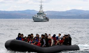 مهاجرون في بحر إيجة وخلفهم سفينة تتبع لوكالة 