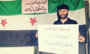 شاب يرفع لافتة ترفض انتخابات الأسد 21 من أيار 2021 (فيسبوك)