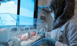 ممرضة تجري فحصًا لطفل ضمن حضانة في مستشفى شفق للرعاية النسائية وحديثي الولادة - 22 أيار 2021 (منظمة شفق)