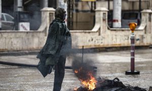 عنصر من قوى الأمن الداخلي التابعة لقوات سوريا الديمقراطية يتدفأ على النار في مدينة القامشلي - 31 كانون الثاني 2021 (AFP)