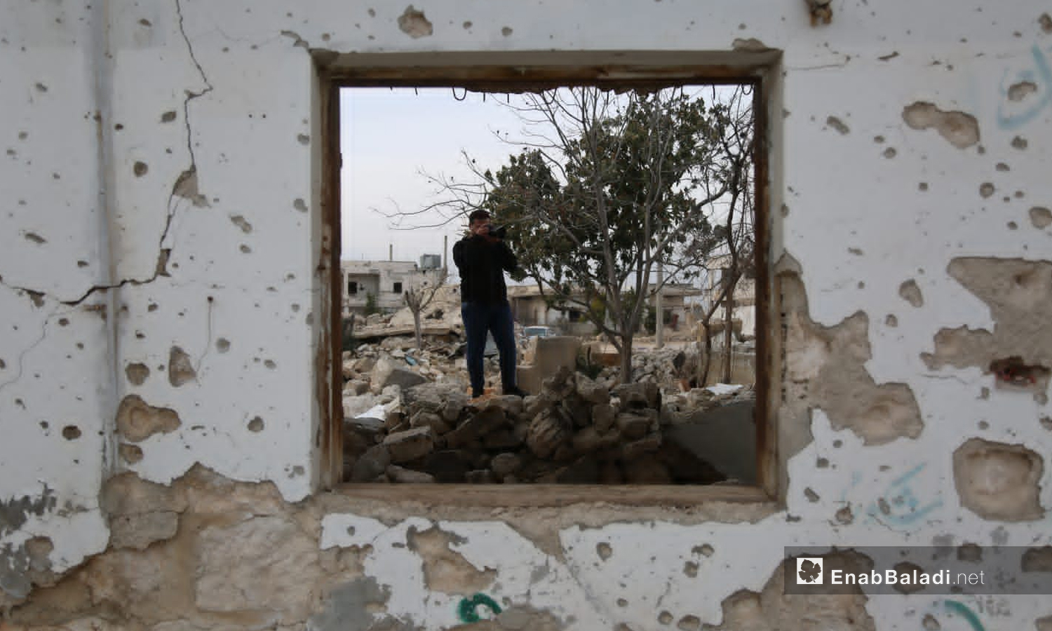 صحفي يصور أنقاض المنازل التي قصفها النظام السوري في إدلب (عنب بلدي)