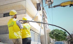 عمليات توصيل الكهرباء في مدينة سلقين شمالي إدلب من قبل عمال شركة - 17 حزيران 2021 (Green Energy)