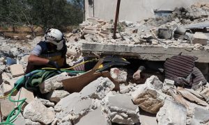 عنصر من الدفاع المدني يحاول انتشال مدني من تحت أنقاض نزله جنوبي إدلب – 6 حزيران 2021 (الدفاع المدني) 