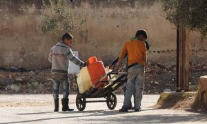 طفلان سوريان يحملان عبوات مملوءة بالمياه عبر جرار حديد وسط أزمة مياه تعيشها بلدات في ريف حمص الشمالي- 20 تشرين الثاني 2017 (موقع 