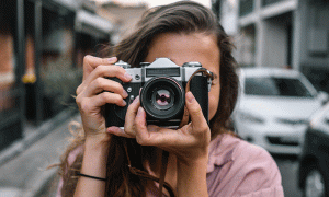 فتاة تحمل كاميرا لالتقاط صورة- تعبيرية (npshopping)